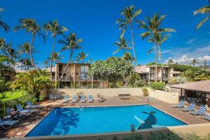 a pool at a resort with palm trees at Kihei Garden Estates D104 condo in Kihei