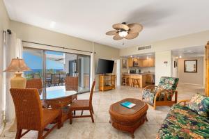 een woonkamer met een tafel en een bank bij Big Island Royal Sea Cliff 705 condo in Kailua-Kona
