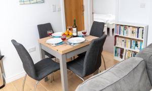 a dining room table with chairs and wine glasses at Puffin 4 - The Cove in Brixham