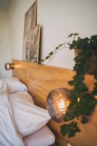 Una cama con un cabecero de madera con una lámpara. en Hotel restaurant SAM en Tholen