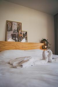 ein Bett mit weißer Bettwäsche und einem Kopfteil aus Holz in der Unterkunft Hotel restaurant SAM in Tholen