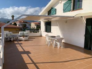 un patio con tavolo e sedie su una casa di Villa Maria Apartments a Capoterra