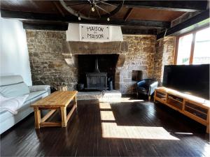 a living room with a couch and a fireplace at Maison de Maison in Maël-Pestivien