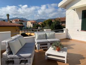 un patio con 2 sedie e un tavolo sul balcone di Villa Maria Apartments a Capoterra