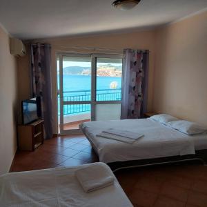 a bedroom with two beds and a view of the ocean at Apartmani Orange Dreams in Sutomore