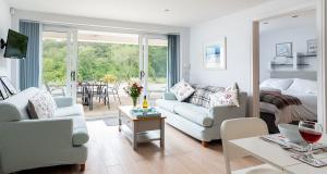 a living room with a couch and a bed and a table at Sandpiper 3 - The Cove - Stunning views, Heated Pool, Allocated Parking in Brixham