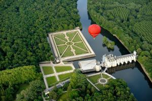 un ballon rouge survolant un château dans la forêt dans l'établissement Loire Valley village centre apartment chezANIA, à Le Grand-Pressigny