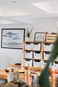 a room with a table and a shelf with boxes at BodyGo Surfhouse in Capbreton