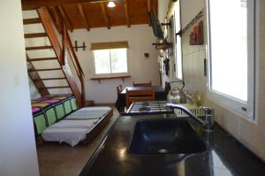 una cocina con fregadero en una casa pequeña en Rancho Pampa en Villa Ciudad Parque