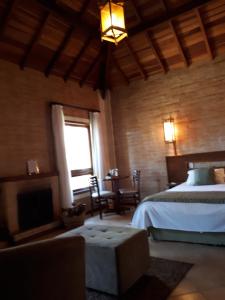 a bedroom with a bed and a fireplace at Pousada Bucaneve in Monte Verde