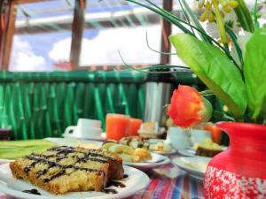 a table with plates of food and a vase of flowers at Hostal Cusco Internacional in Cusco