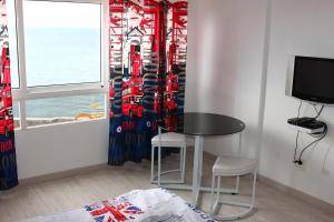 une chambre avec une table, des chaises et une fenêtre dans l'établissement Los Abrigos Sea-Port View, à Los Abrigos