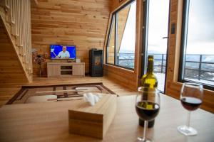 a room with a bottle of wine and two glasses at Cez A-Frame in Petroşani
