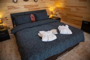 a bedroom with a bed with towels on it at Cez A-Frame in Petroşani