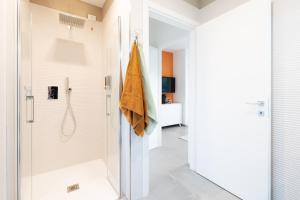 La salle de bains est pourvue d'une douche et d'une porte en verre. dans l'établissement LOUXORY ACCOMODATION CAGLIARI, à Cagliari