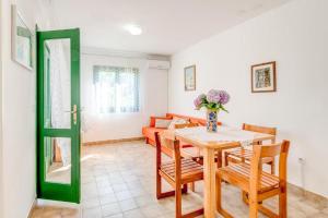 a dining room with a table and chairs and a couch at Povlja Bungalows in Povlja