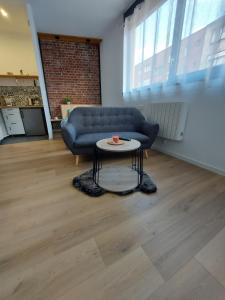 sala de estar con sofá azul y mesa en Studio confort #2, proche Gare et commodités en Maubeuge