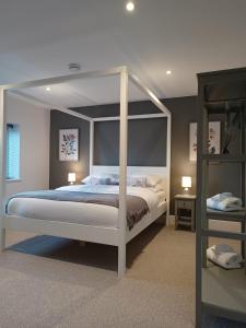 a bedroom with a white canopy bed in it at The Stables at Eriviat Hall in Henllan