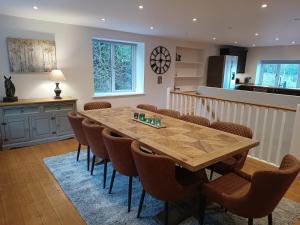 a kitchen and dining room with a wooden table and chairs at The Stables at Eriviat Hall in Henllan