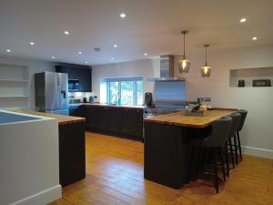 a kitchen with black cabinets and a wooden counter top at The Stables at Eriviat Hall in Henllan