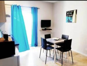 a dining room with blue curtains and a table and chairs at Valletta Apartment with Harbour Veiw in Valletta