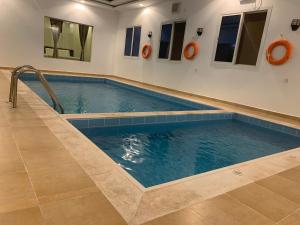 a swimming pool in a room with a tile floor at فيلا المنزل in Makkah