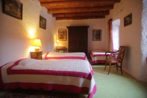 Pokój hotelowy z 2 łóżkami i krzesłem w obiekcie Chez Caroline chambres d'hôtes w mieście Bains +22 zdjęcia