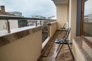 balkon z 2 krzesłami na dachu budynku w obiekcie Apartament Tiana Lux w mieście Chisaria