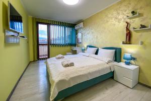 ein Schlafzimmer mit einem großen Bett mit gelben Wänden in der Unterkunft Apartament Tiana Lux in Chissarja