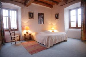 um quarto com uma cama, 2 candeeiros e uma cadeira em Chez Caroline chambres d'hôtes em Bains