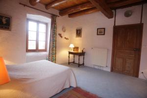 um quarto com uma cama, uma janela e uma mesa em Chez Caroline chambres d'hôtes em Bains