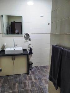 La salle de bains est pourvue d'un lavabo et d'un miroir. dans l'établissement CASA LOKO Guest House, à Louxor