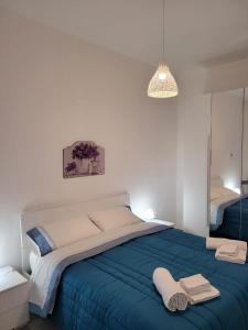 een slaapkamer met een groot bed en handdoeken bij Casa Vacanze L'Ortensia in Bagheria