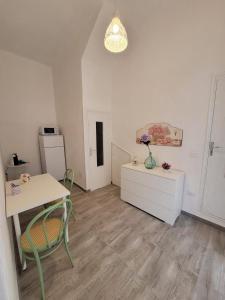 een woonkamer met een tafel en een koelkast bij Casa Vacanze L'Ortensia in Bagheria