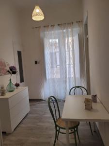 een keuken met een tafel en stoelen en een raam bij Casa Vacanze L'Ortensia in Bagheria
