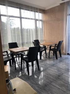a room with tables and chairs and a large window at HOTEL GUGA in Kobuleti