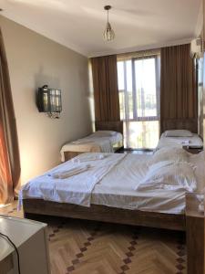 two twin beds in a room with a window at HOTEL GUGA in Kobuleti