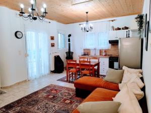 a living room with a couch and a kitchen at Cozy cottage for 4 in Lávdhas