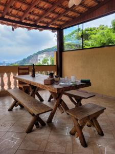 a picnic table with benches and a large window at Santo Mirante Hostel in Rio de Janeiro