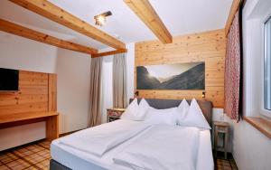 a bedroom with a white bed and a television at Home suite home in Fieberbrunn +169 photos