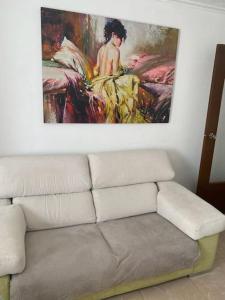 una sala de estar con sofá y una pintura en la pared en Appartement Célia, en Algemesí