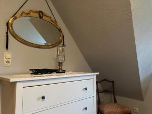 a dresser with a mirror and a lamp on it at Haus am Hafen - Kaminfeeling unter Reet in Prerow