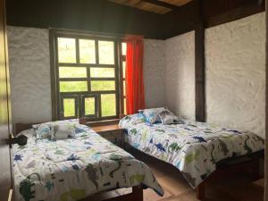 1 dormitorio con 2 camas y ventana en El Paramo, en Paipa