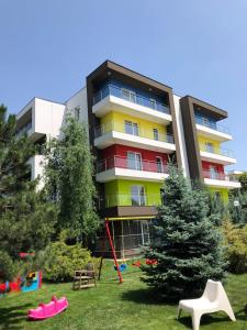 un immeuble d'appartements avec une aire de jeux en face dans l'établissement Star Airport Residence, à Otopeni