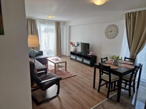 a living room with a table and a dining room at Star Airport Residence in Otopeni