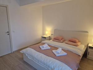 a bedroom with a bed with two towels on it at Star Airport Residence in Otopeni +43 photos