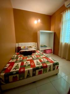 een slaapkamer met een bed met een quilt bij DeSyafiq Homestay in Kuala Kedah