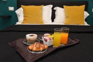 a tray of breakfast foods and drinks on a bed at Hotel Kennedy in Naples