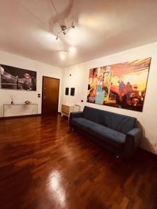 a living room with a couch and paintings on the wall at Appartamento tra Aeroporto DaVinci e Fiera di Roma in Fiumicino