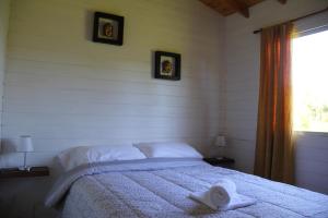 Un dormitorio con una cama con una toalla. en Cabaña El Mahayana en Tigre